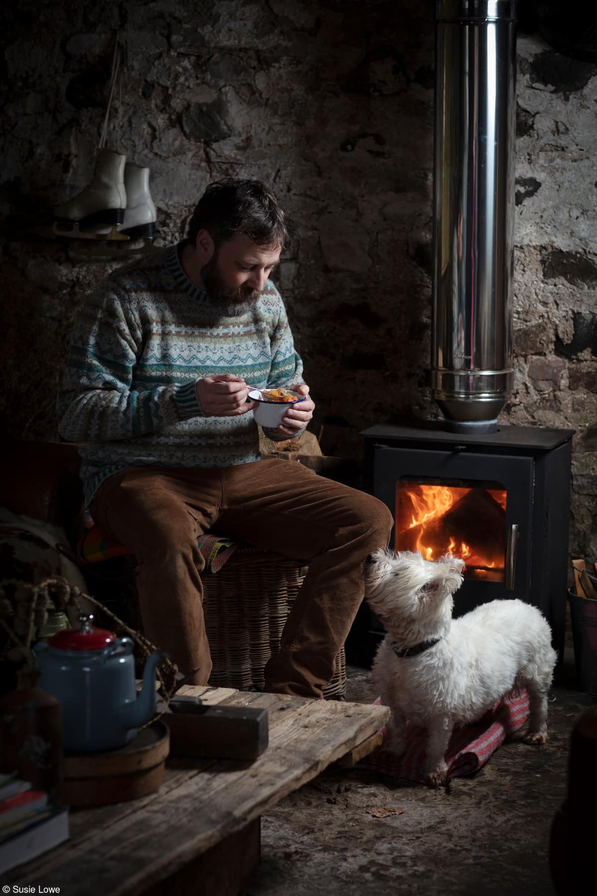 Peter enjoying his Scotch Broth by the fire with his dog, Seoras by Susie Lowe