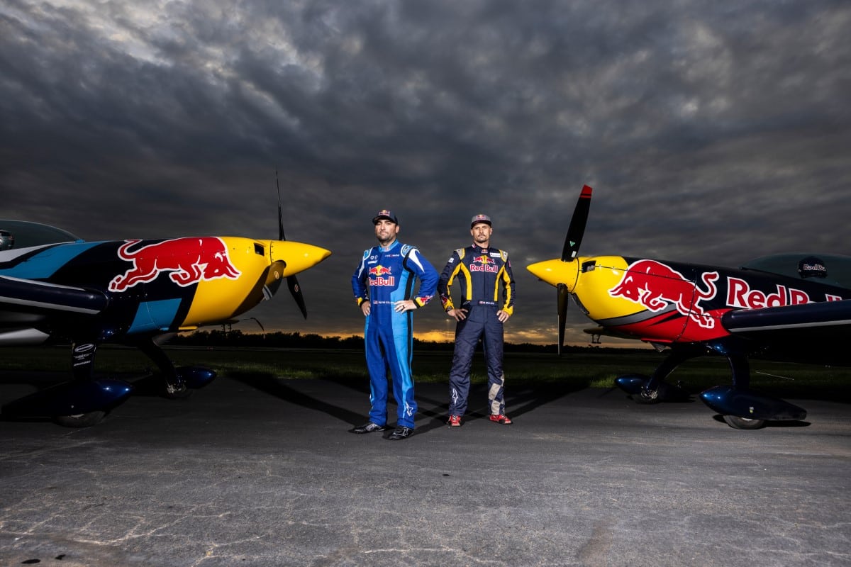 Redbull aerobatic pilots standing in front of planes