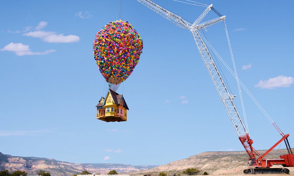 A crane raises the house from Up for AirBnB Icons. The desert of New Mexico is in the background