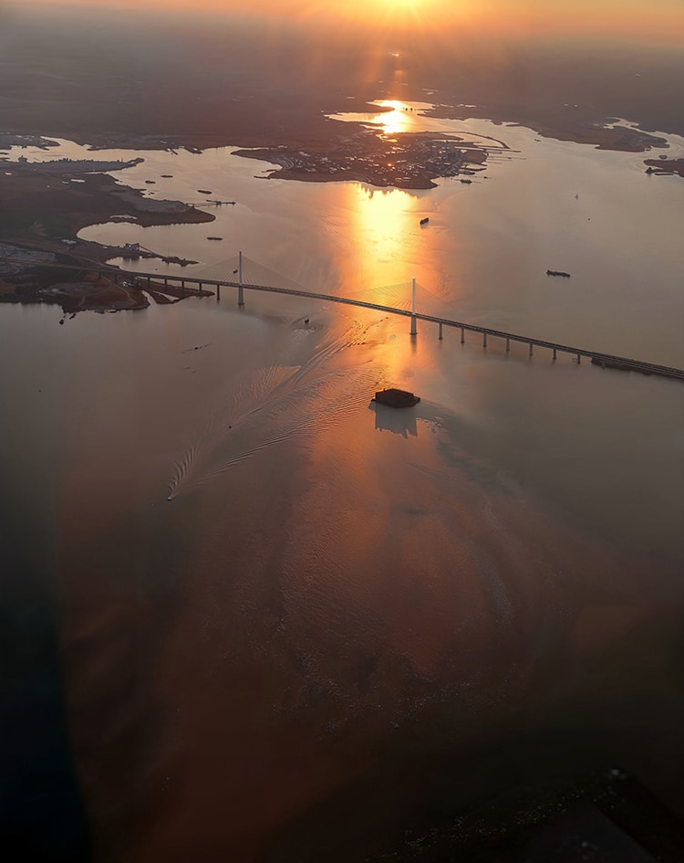 A photograph of the sun setting over a cable-stayed bridge which is the proposed replacement for Baltimore's Francis Scott Key bridge