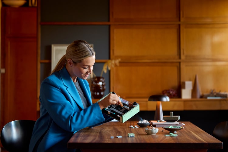 woman assembling LEGO icons retro radio