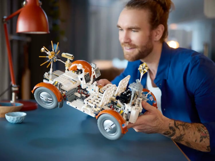 Man assembling LEGO NASA Apollo Lunar Roving Vehicle model set