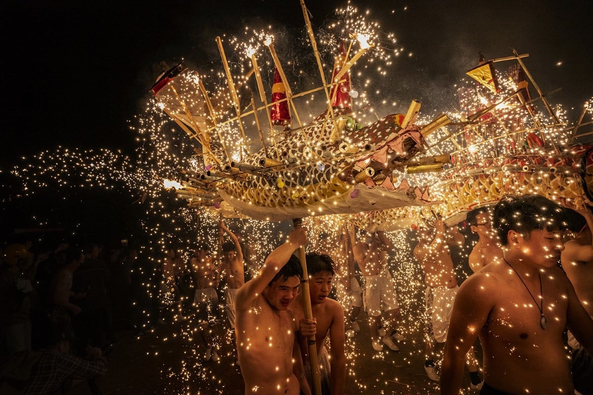 중국 메이저우의 사람들은 뜨거운 불꽃놀이와 같은 불꽃을 맞으며 음력 첫 보름달에 등불 축제를 축하하기 위해 불용 춤을 춘다.<BR>