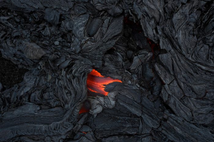 Aerial photo of molten lava surrounded by cooled lava