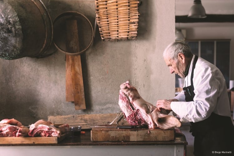 Elderly Italian man butchering a pig