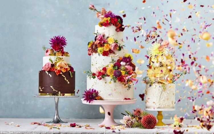 Three colorful cakes decorated with edible flowers