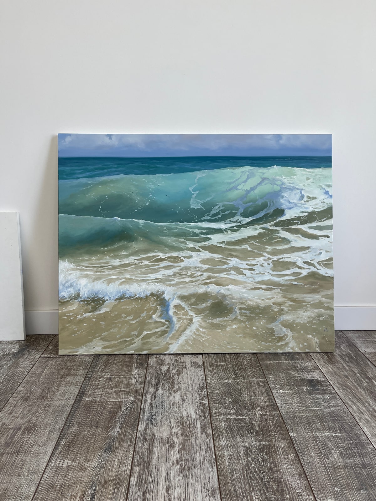 Artist Alexandra Velichko poses with ocean paintings