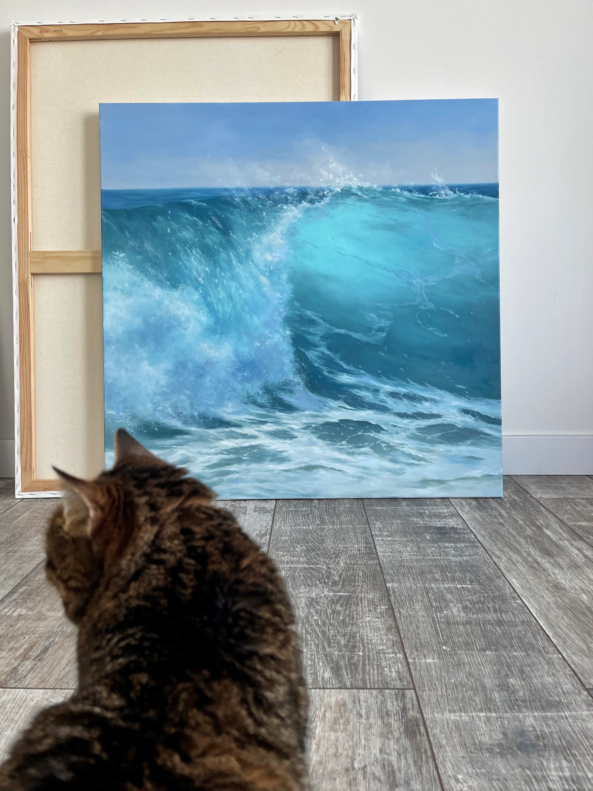 Artist Alexandra Velichko poses with ocean paintings