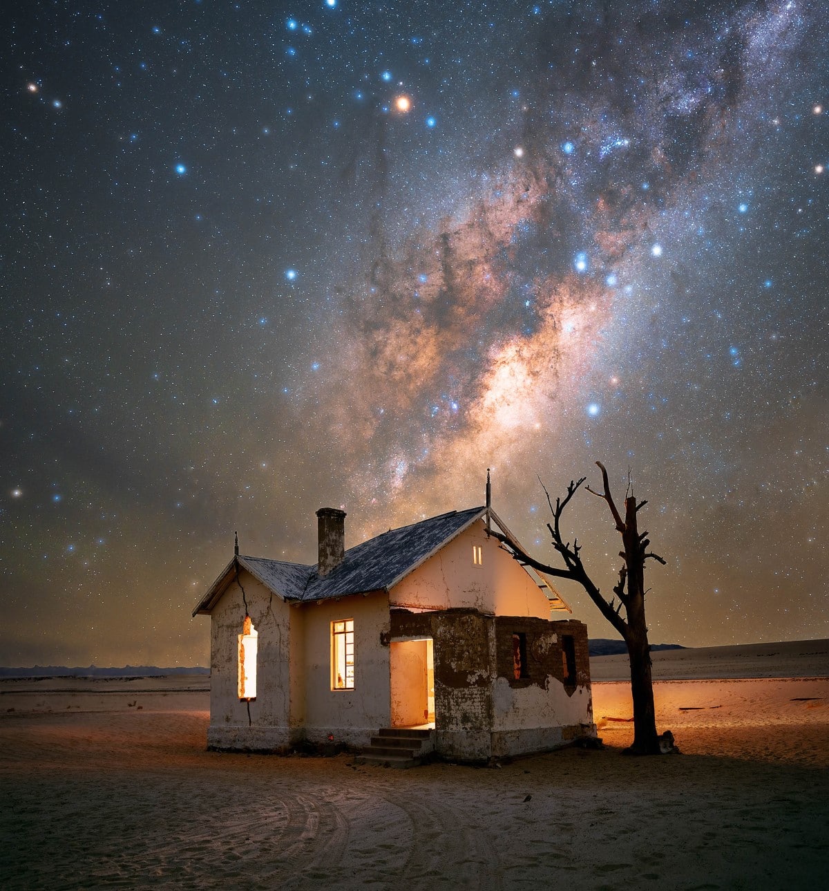 Abandoned house in the middle of the Namib Desert with the Milky Way rising above it