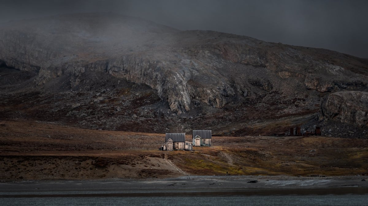 Moody image of a house in front of the mountains