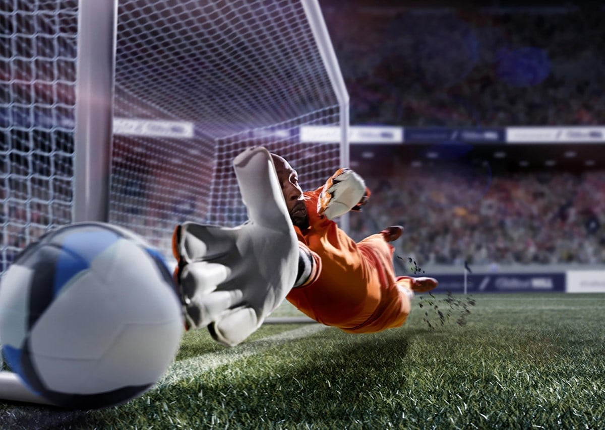 Goalie reaching for a soccer ball