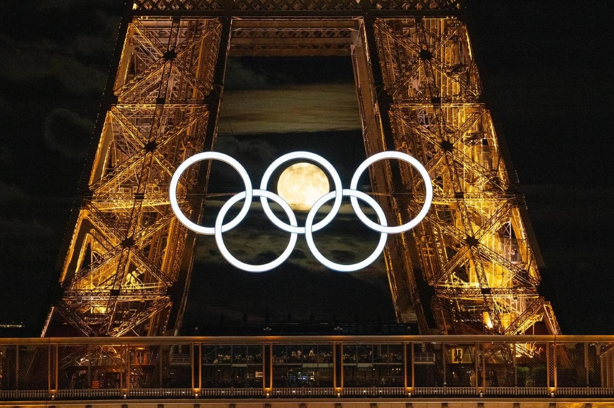 Full moon inside Olympic Rings hung on the Eiffel Tower