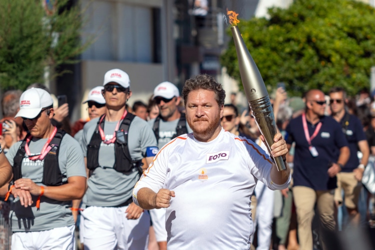  French radio host and humorist Clment Lanoue Olympic torch bearer on the promenade bordering the beach at Les Sables d'Olonne for the Paris 2024 Summer Olympic Games
