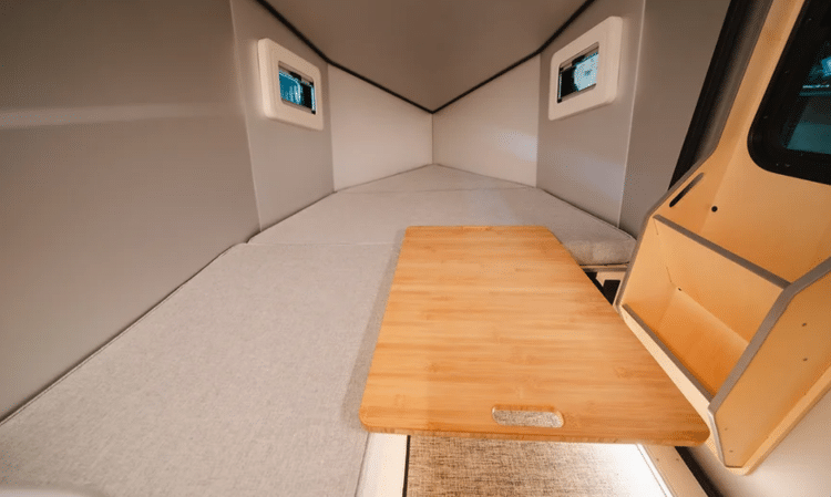Interior Shot Of Camper With Double Bed And Wooden Pad For Child's Bed