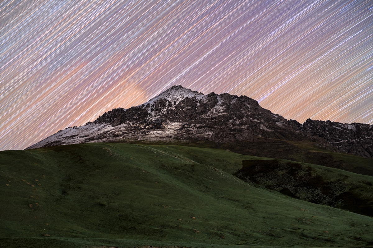 Star Trail picture taken against snowy mountain Kyrgyzstan