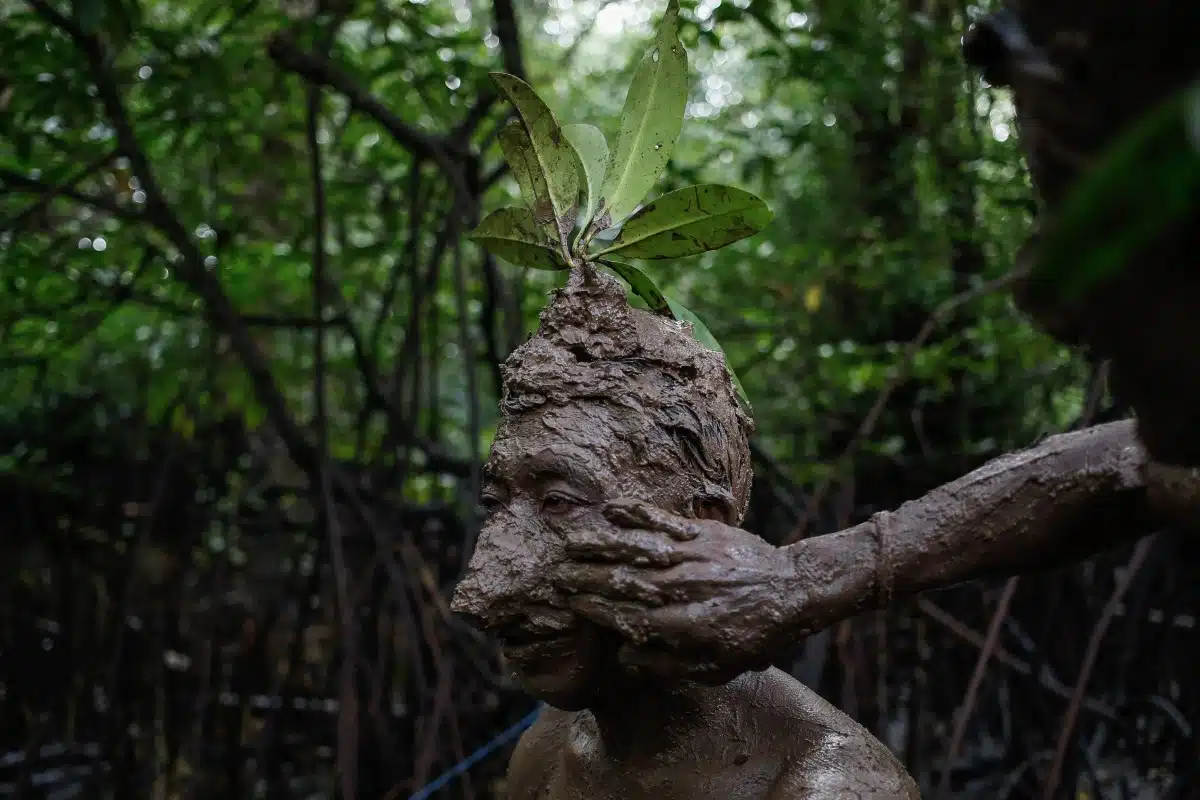 Local Balinese man is covered in mud during a bathing tradition, locally known as Mebuug Buugan.