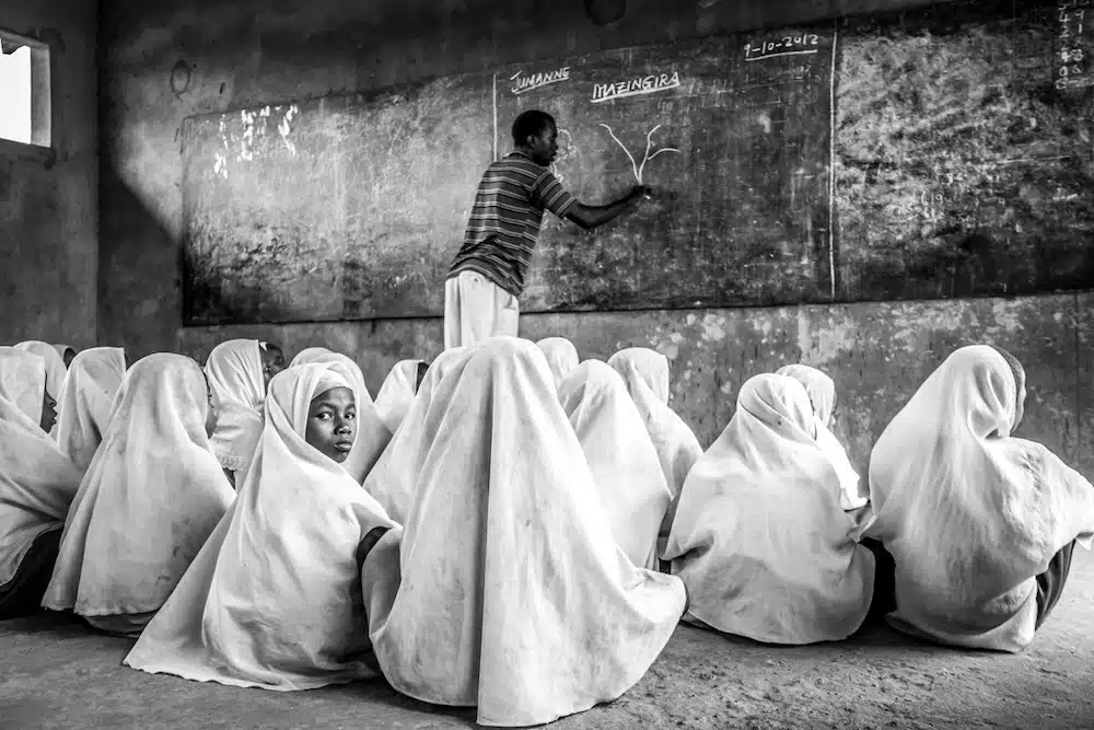 Teacher at blackboard in classroom of girls with burquas