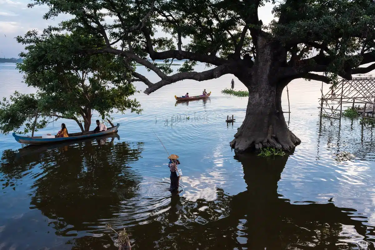 Early evening view of people boating on Lake Taungthaman from the U Bein Bridge, Amarapura, Myanmar.