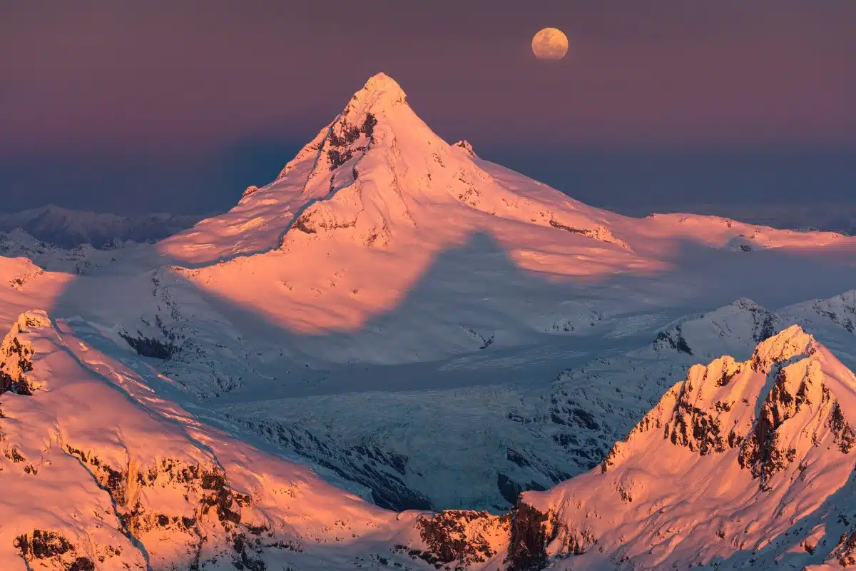 Aerial photo of the mountains at sunset with the Moon in the background