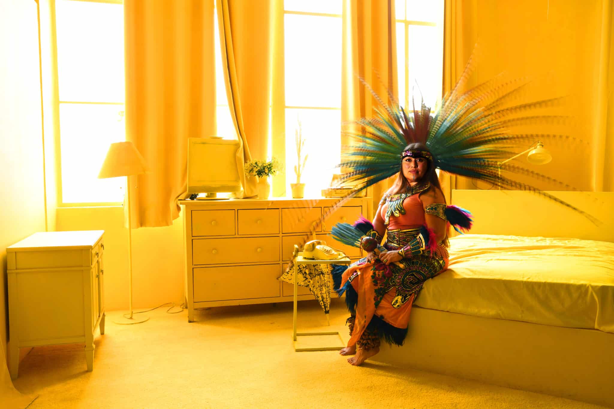 Nahuatl woman sitting in a yellow bedroom