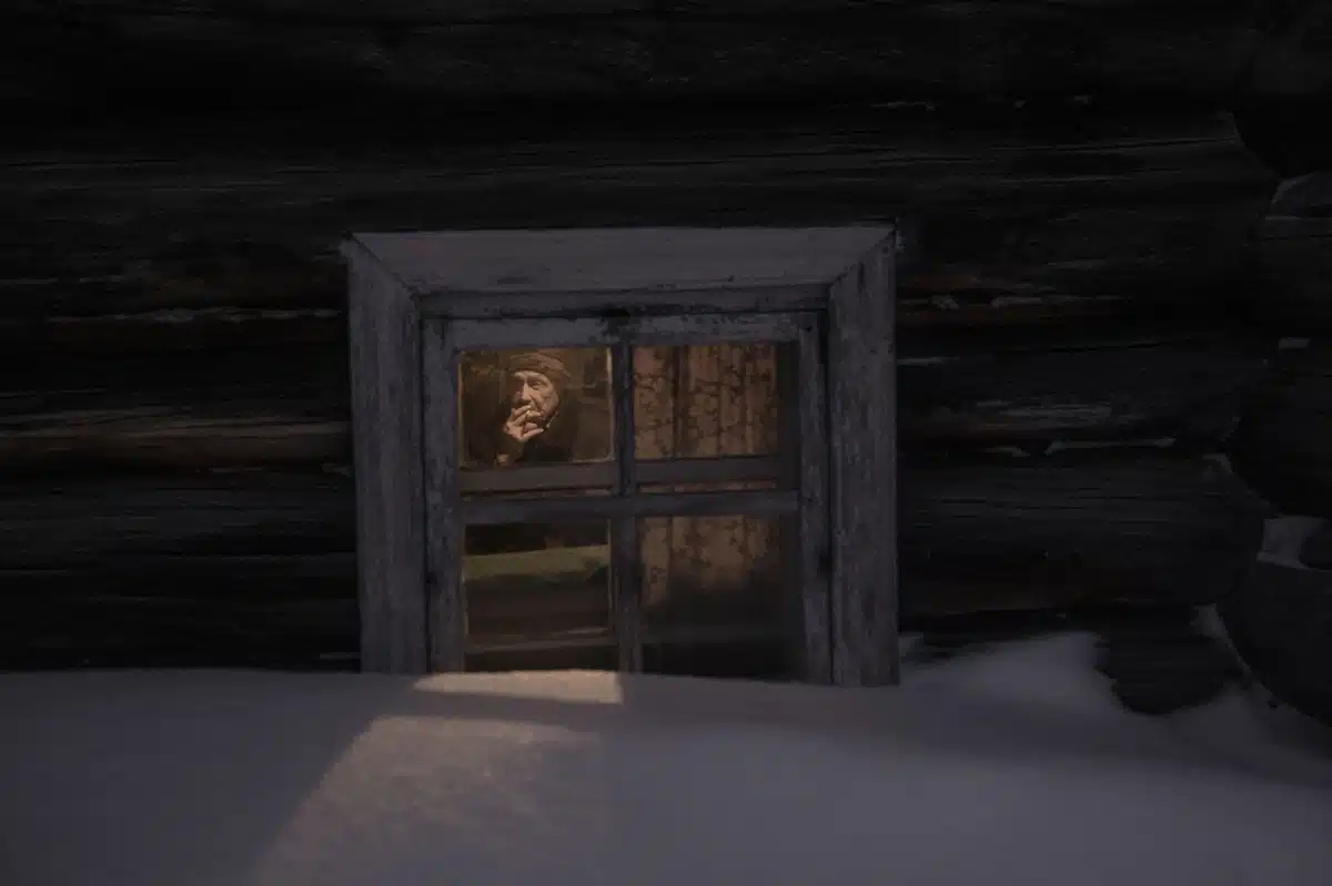 Man in northern Russia looking out of his window while it is buried in the snow