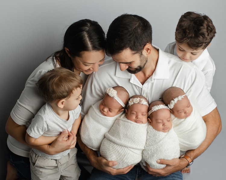 Baby quadruplets with their parents and brother