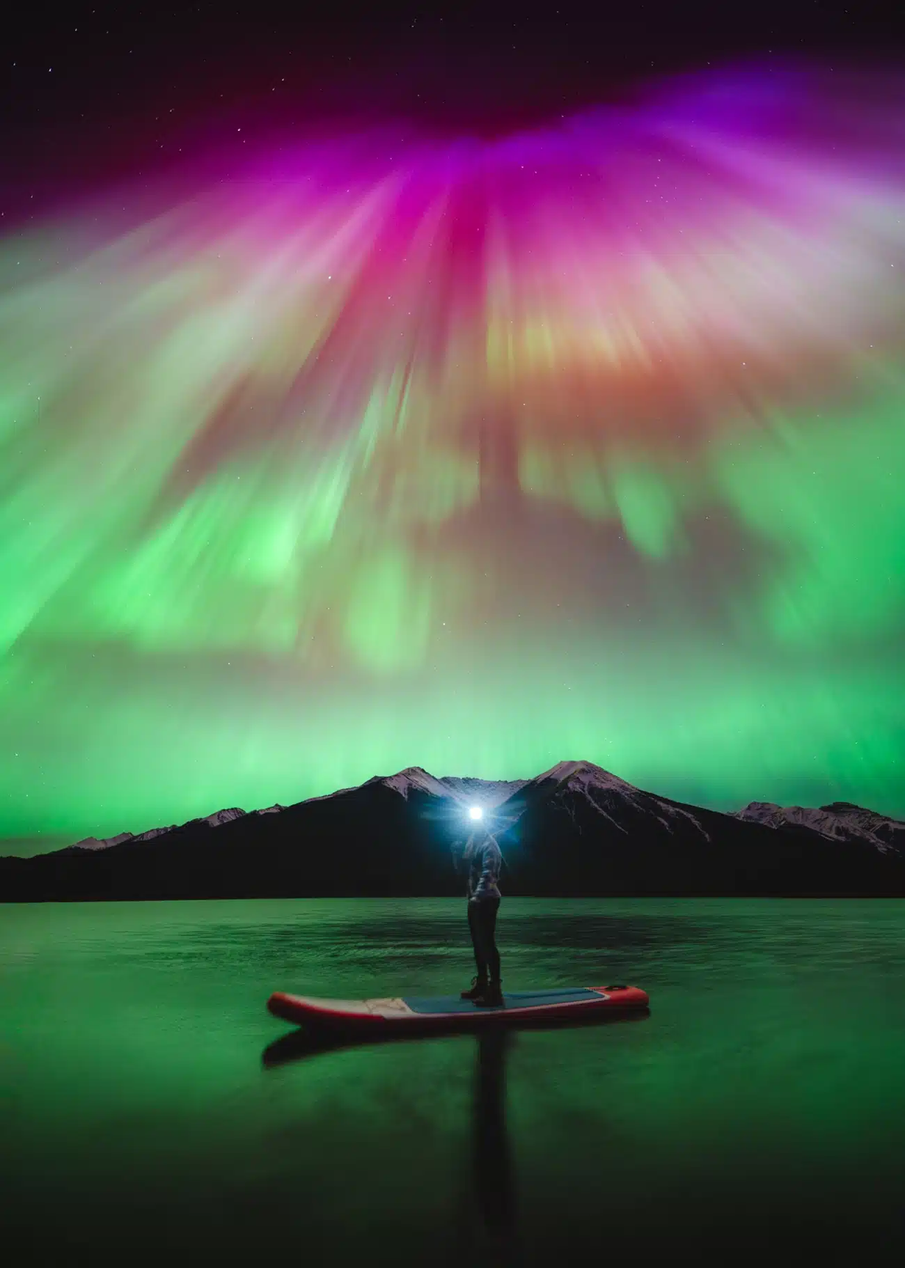 Northern Lights at Banff National Park with man standing in a canoe