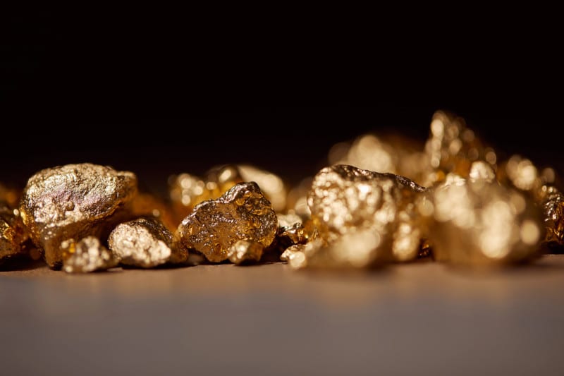 Golden stones on marble on black background