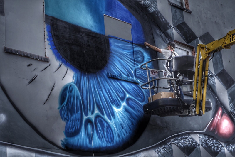 Artist My Dog Sighs painting an eye mural