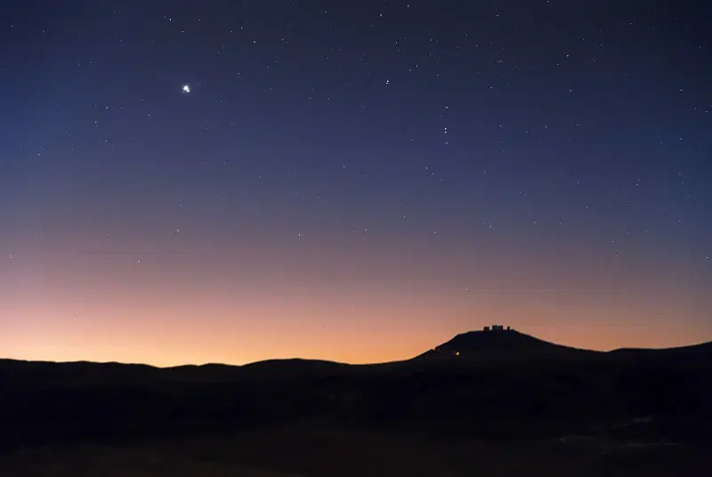 A very bright and large point is the undisputed protagonist of the top half of this picture of the sky above ESO’s Very Large Telescope (VLT) on Cerro Paranal in Chile’s Atacama Desert. Yet if you take a closer look, you will notice it is not just one point, but two, very close to each other. What you see is, in fact, a conjunction of Jupiter and Saturn. Jupiter and Saturn are the two largest planets in the Solar System, almost 320 and 95 times as massive as the Earth, respectively. They are not rocky, like the Earth or Mars, but are mainly made up of hydrogen. They both have tens of moons, many of which we think did not form together with the planets they orbit, but were instead captured at a later stage by their strong gravitational fields.  Conjunctions occur when two objects are aligned in the sky. However, conjunctions are a consequence of the observer’s perspective. If seen not from Earth but another direction, the involved objects will not be aligned. A similar effect holds for constellations, whose shapes, so familiar here on our planet, may not be recognisable when observed from another corner of the galaxy.