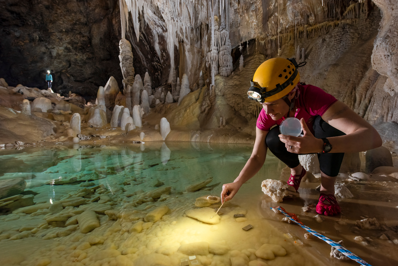 speleologist in Lechuguilla cave studies a pool