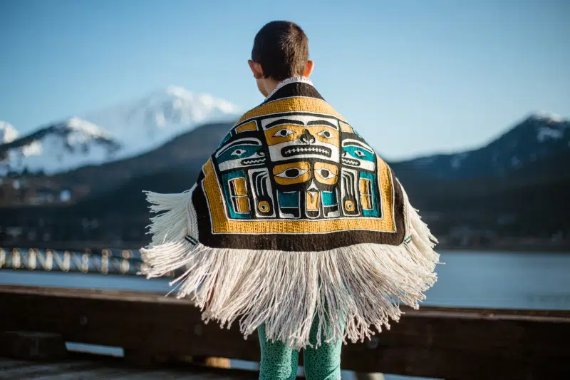 Seven Generations 2.0 Child Sized Chilkat Robe, 2023 Chilkat weaving techniques on thigh spun merino and cedar bark warps, merino weft yarns dyed with copper/ammonia, and wolf moss, and hemlock bark. 32” x 30” including fringe