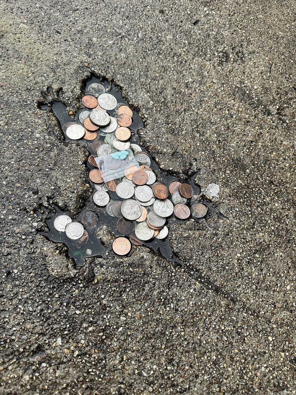 The Chicago rat hole filled with offerings, consisting of mostly coins and a dime bag with estrogen.