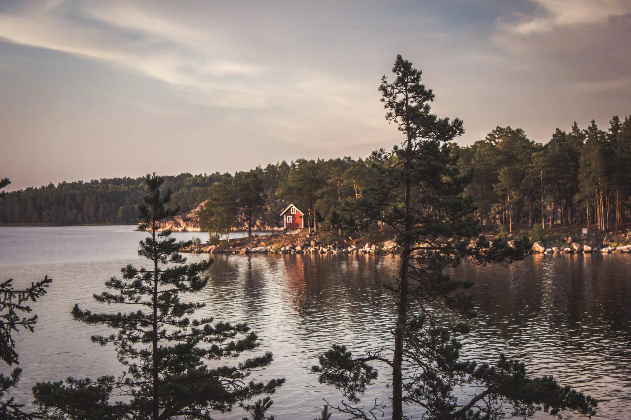 Landscape photograph of a red house close to the water in Sweden