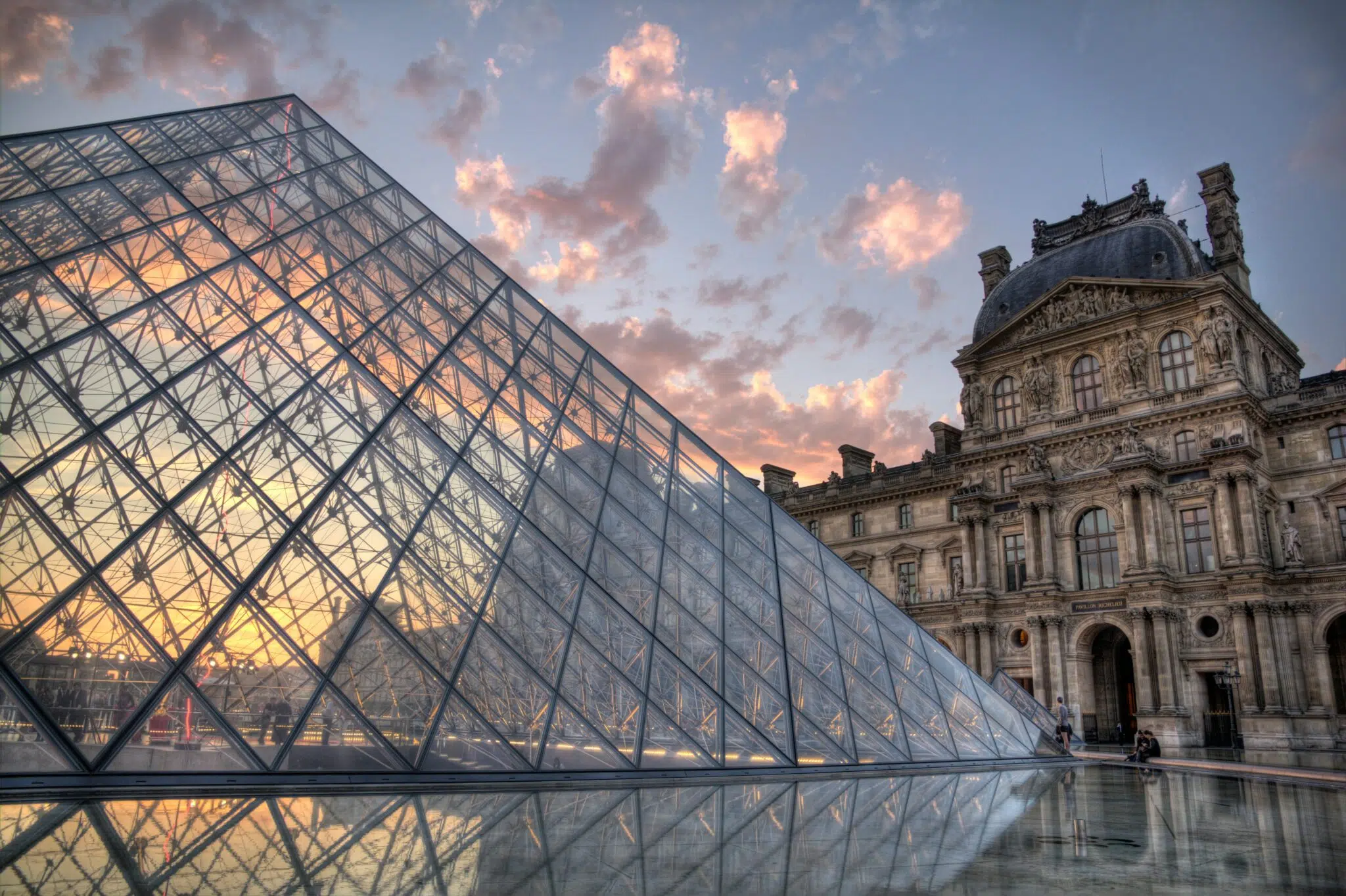 An exterior shot of the Louvre in Paris during sunset