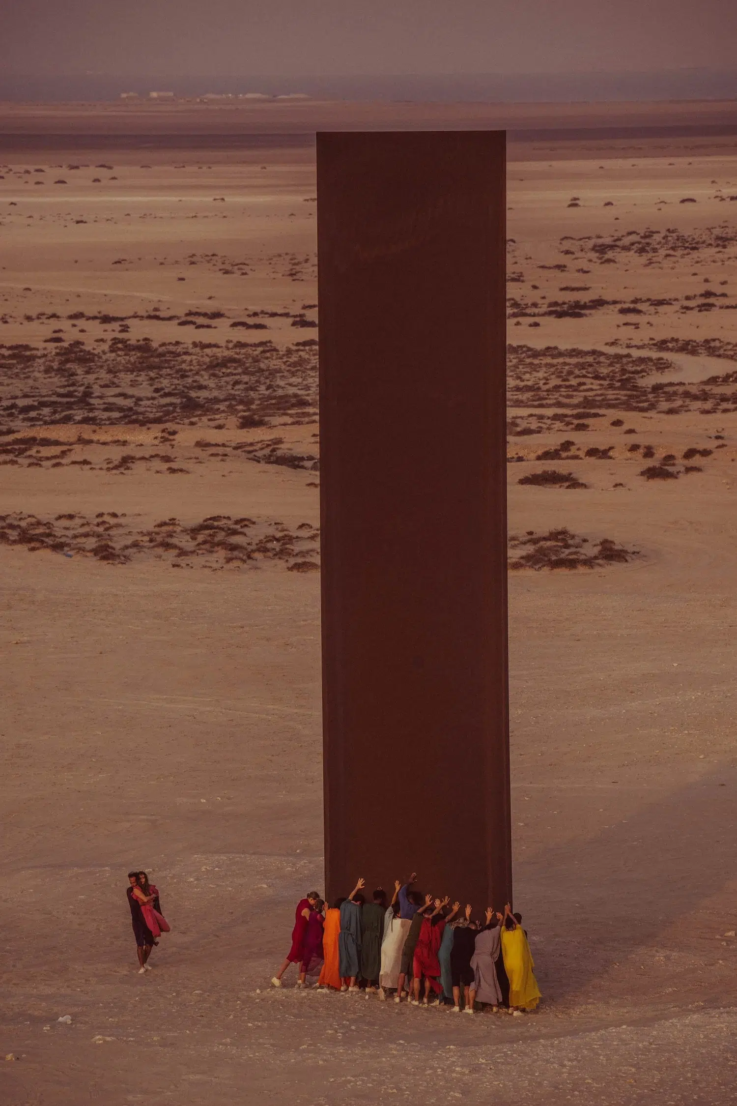 Dance photograph captured by Josh S. Rose, featuring a group of people by a massive installation in the desert