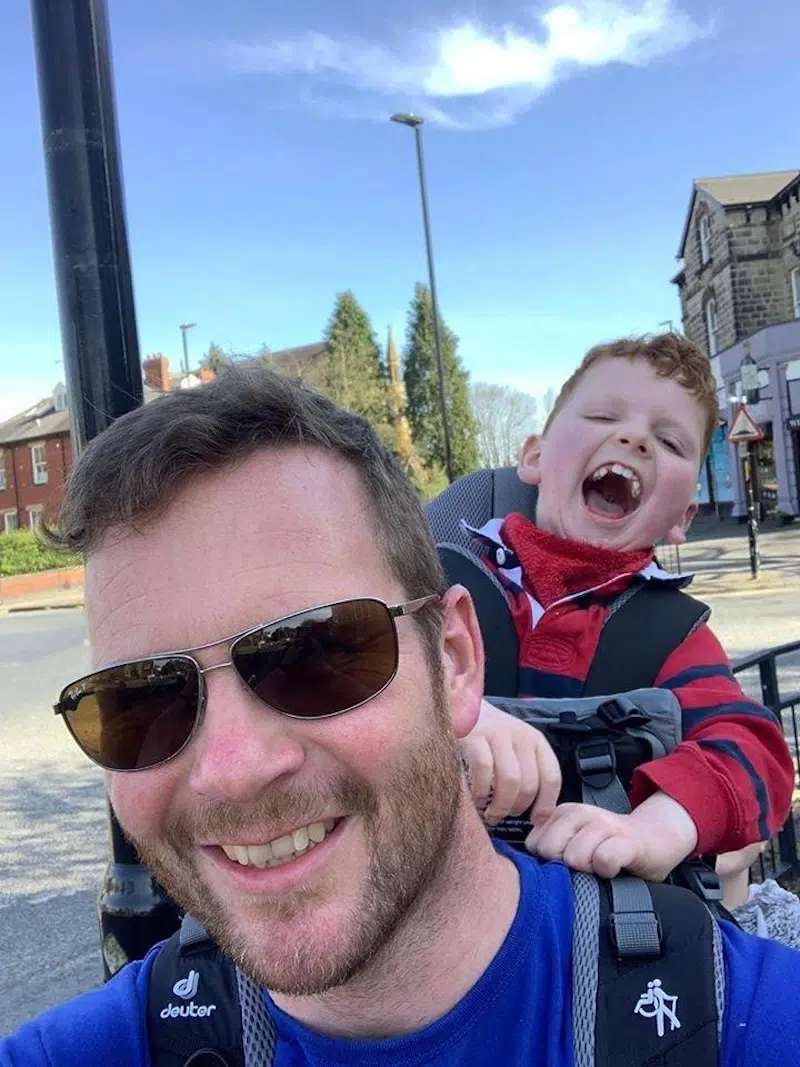 Man Carrying Kid in Backpack