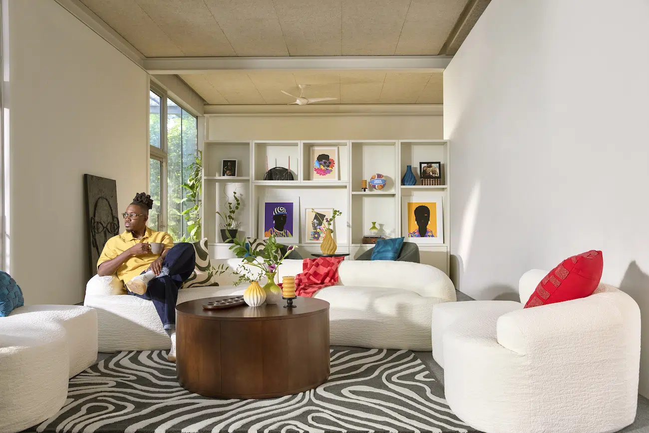 Temi Coker in a living room with products from his recent collaboration with Walmart
