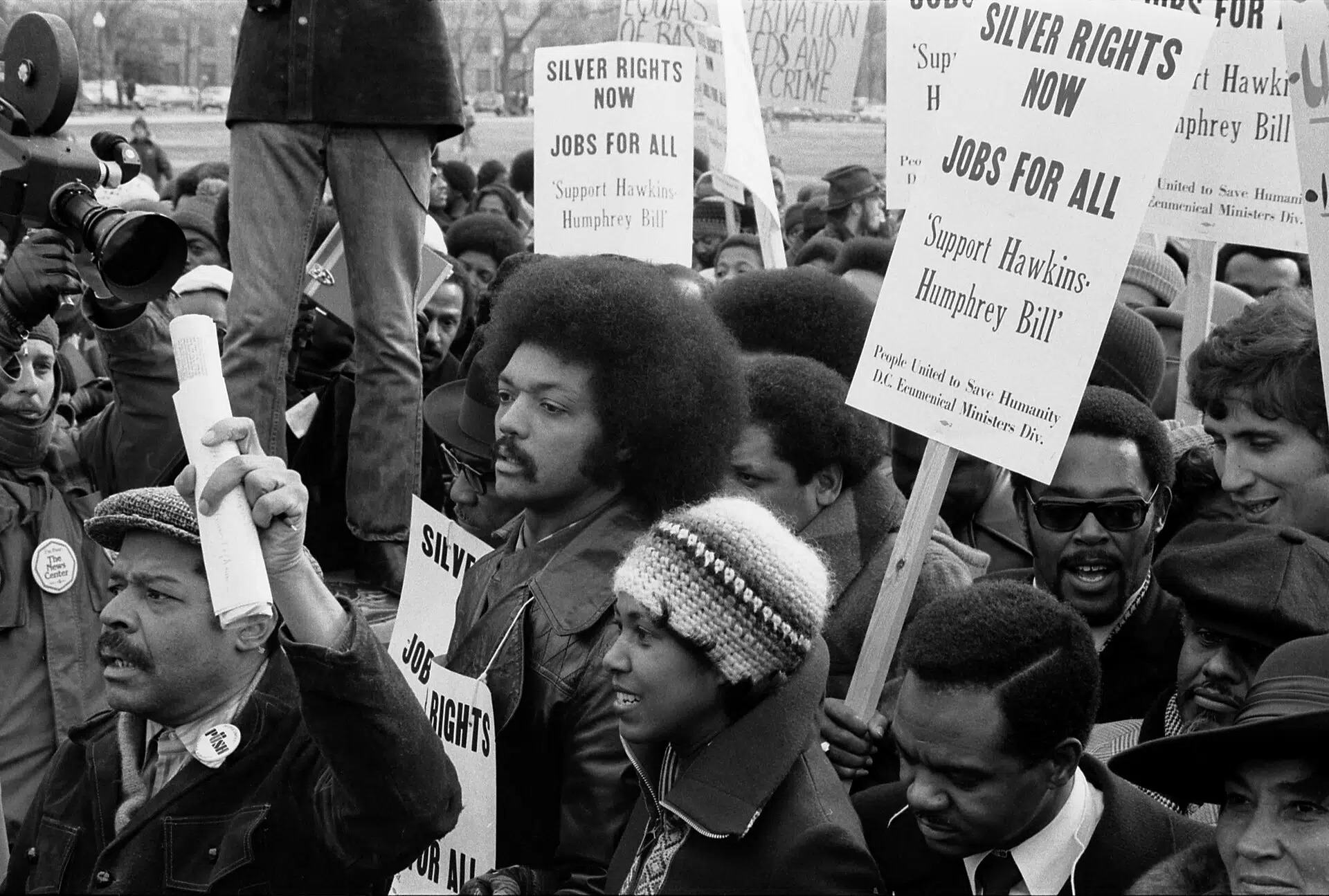 Jesse Jackson surrounded by marchers carrying signs advocating for the Hawkins-Humphrey Bill for full employment near the White House in Washington, D.C., on January 15, 1975