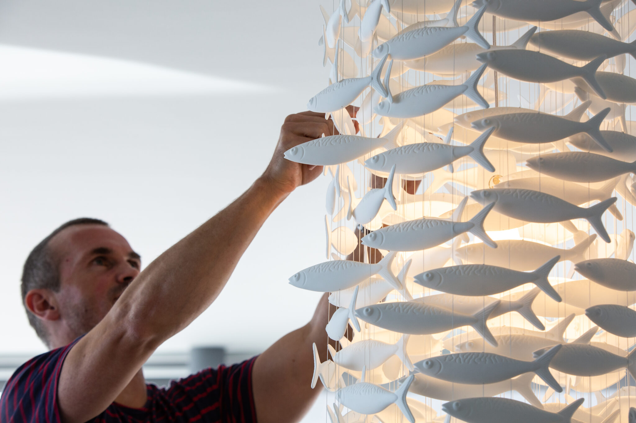 Dom Bromley installing a fish chandelier