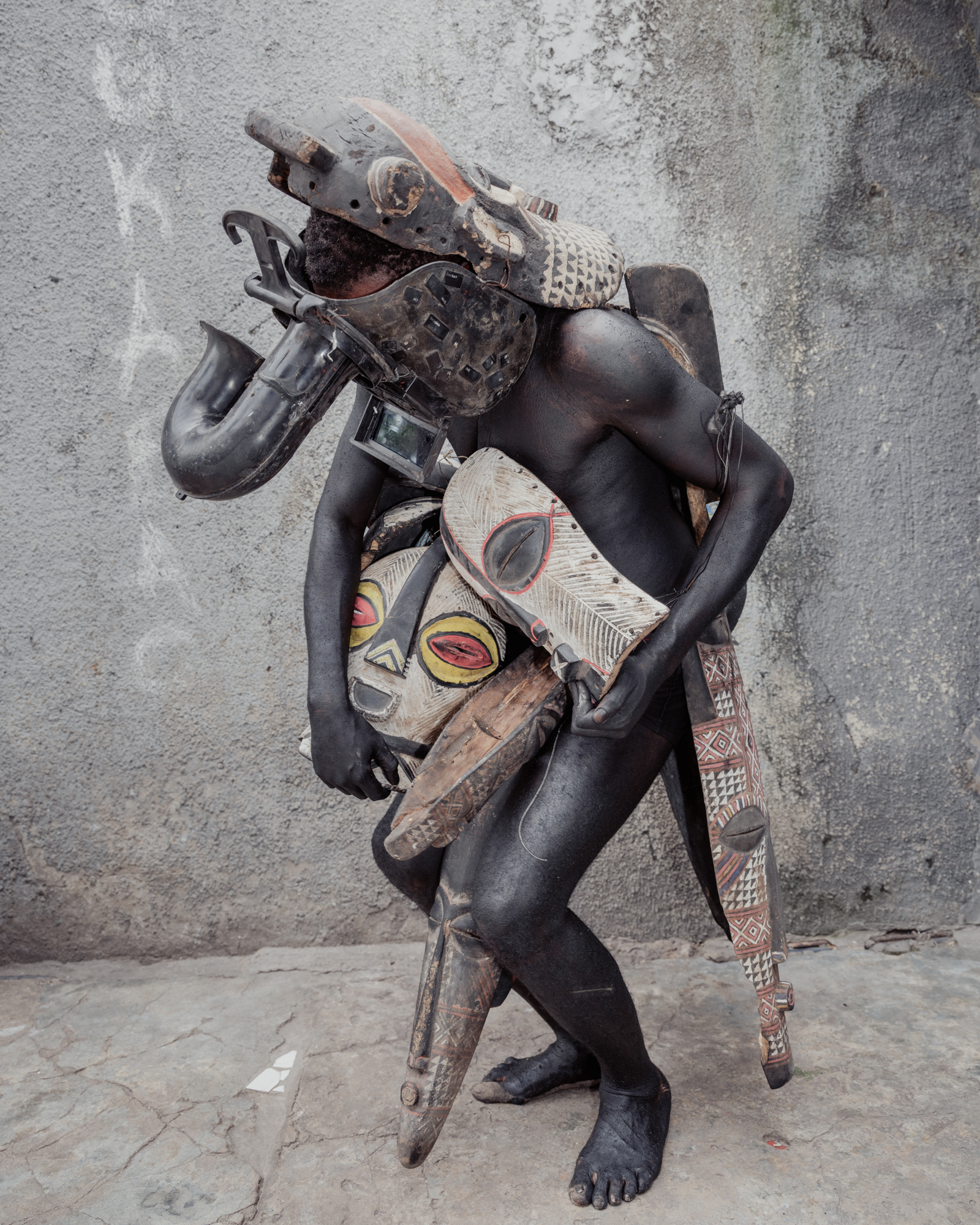 Junior Mungongu (aka 10 Bureaux), a performance artist from Kinshasa, wearing his mask costume on the streets of the Congolese capital.