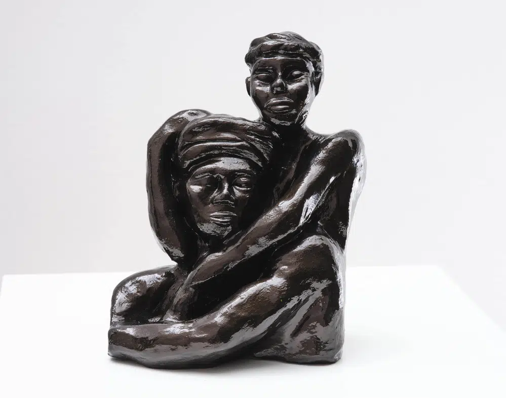 A sculpture by Ashley Nora featuring two people locked in an embrace