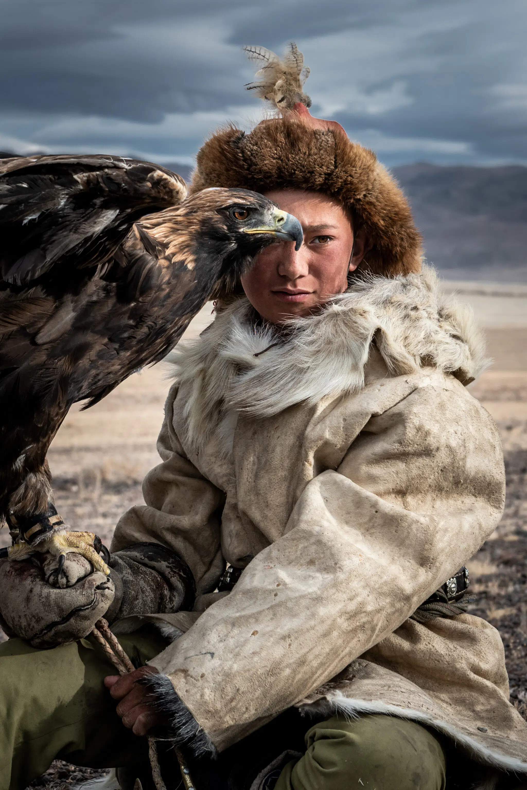 Kazakh eagle hunter Arkalak sits with his golden eagle in the Altai Mountains, where the centuries-old tradition of eagle hunting continues.