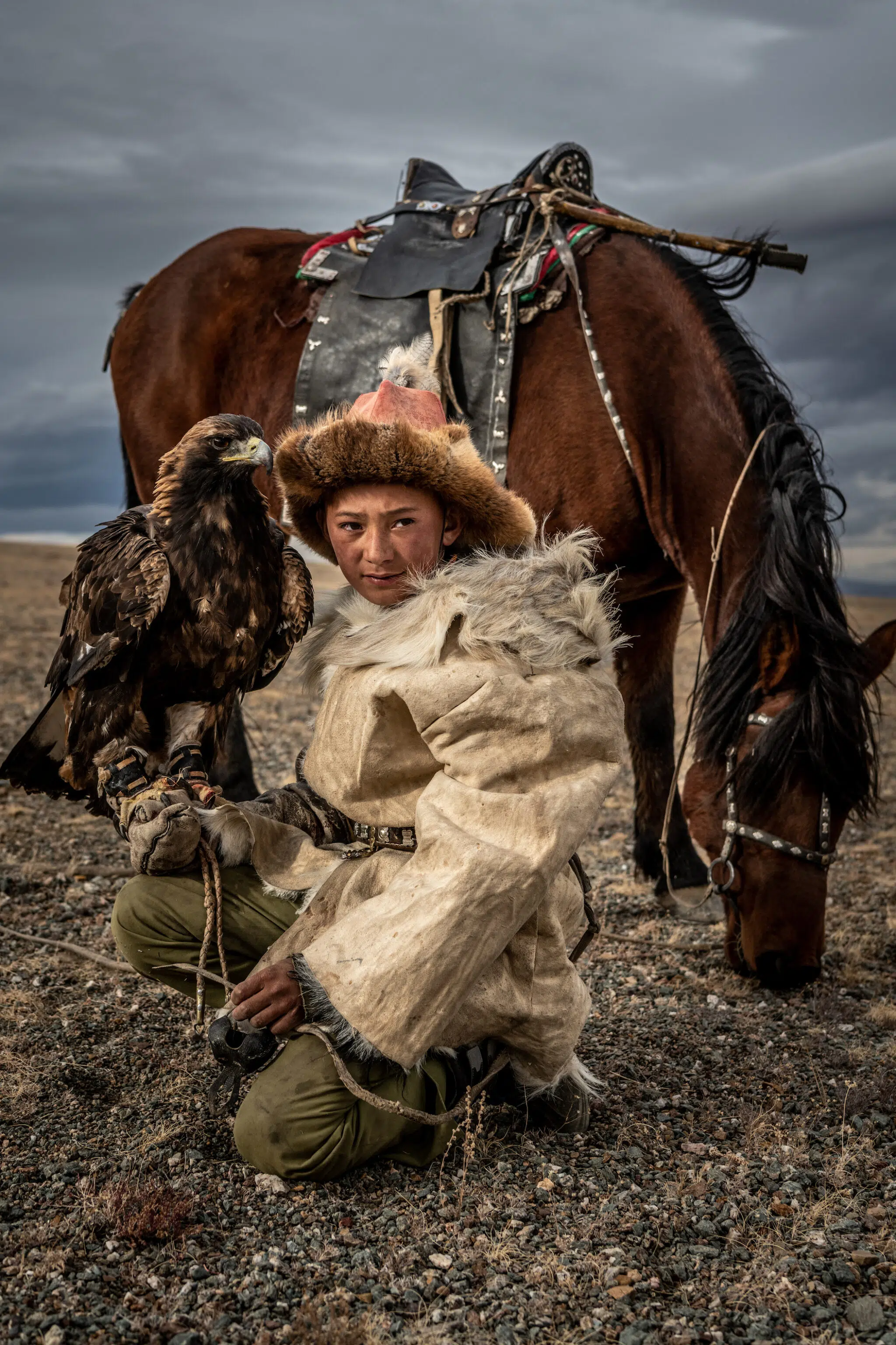 12-year-old eagle hunter Arkalak holds his golden eagle in the Altai Mountains