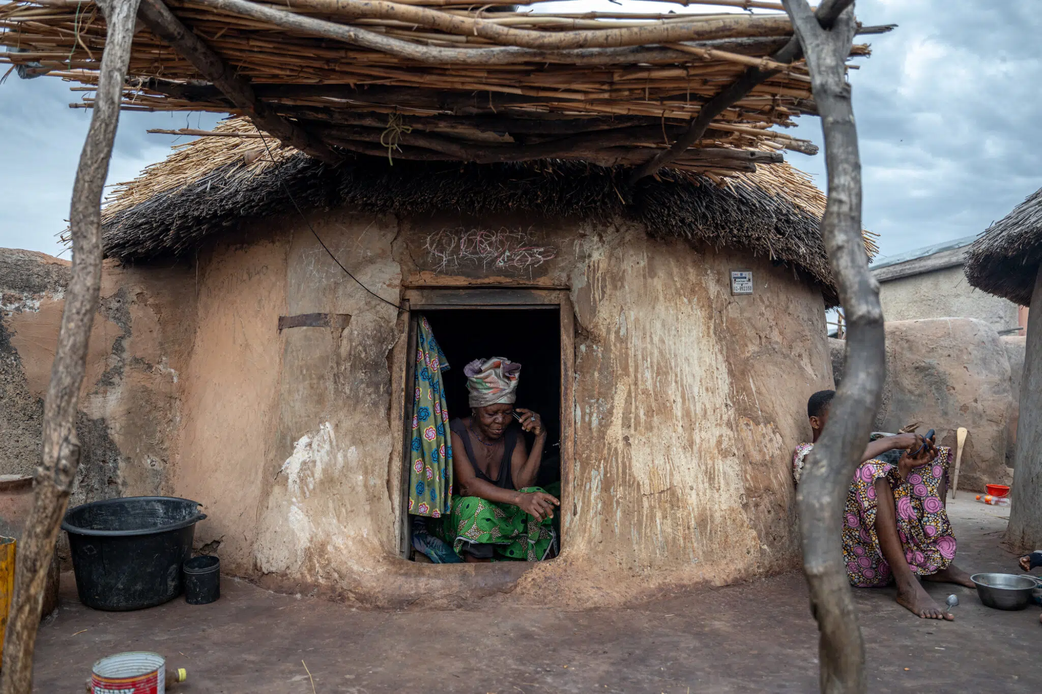 In the Gambaga camp for women accused of witchcraft in Ghana's North East region, a woman speaks on the phone from inside her modest hut.