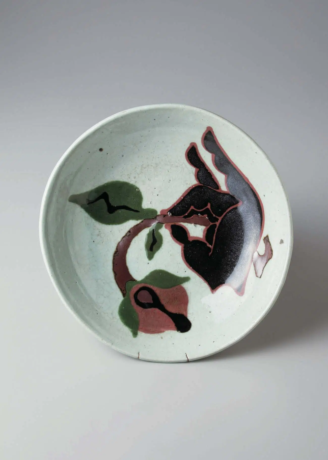 Dish with motif of hand and flower on white background, 1951.