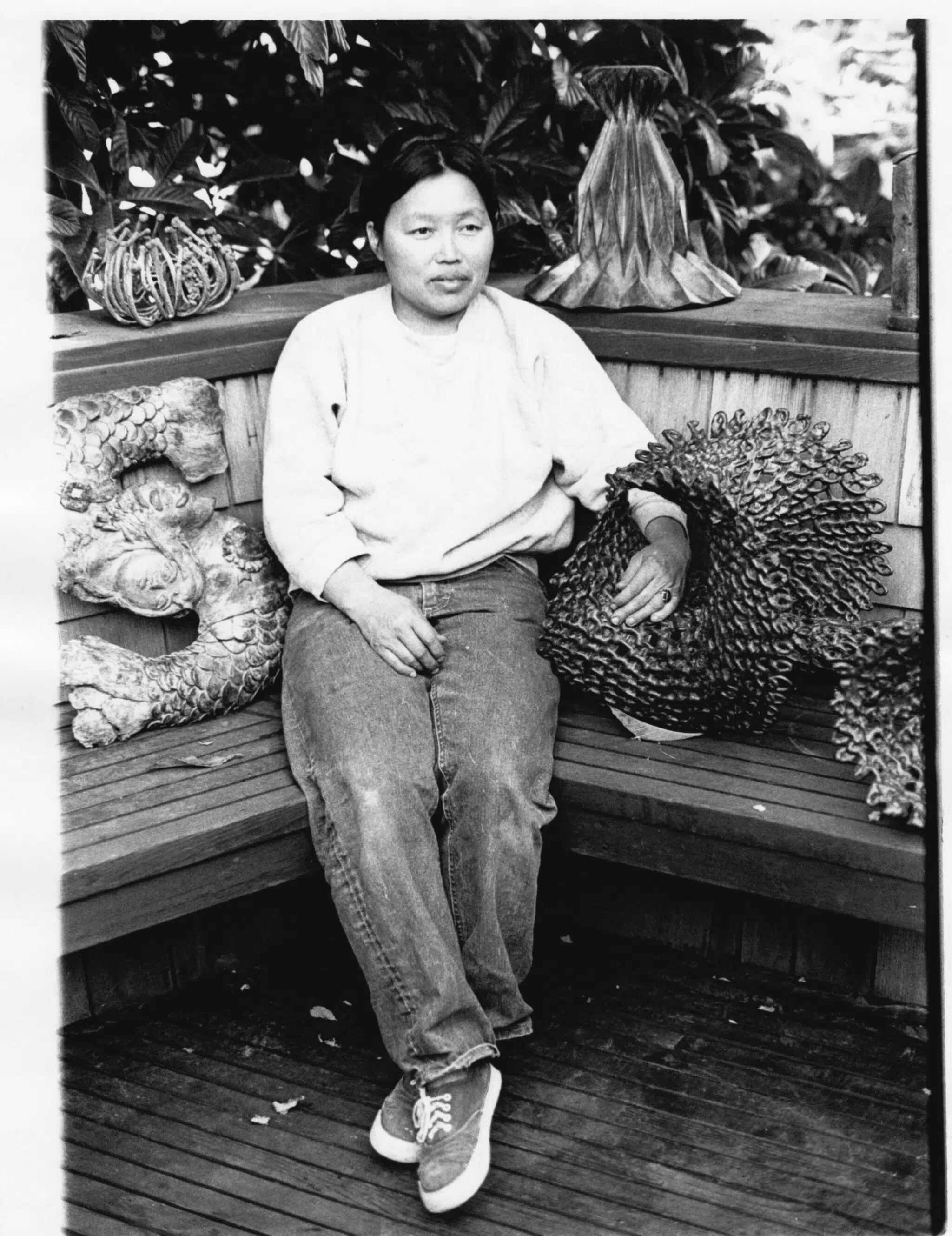 Asawa sitting on the deck of her Noe Valley home with cast bronze and electroplated sculptures, San Francisco, CA, c. 1969