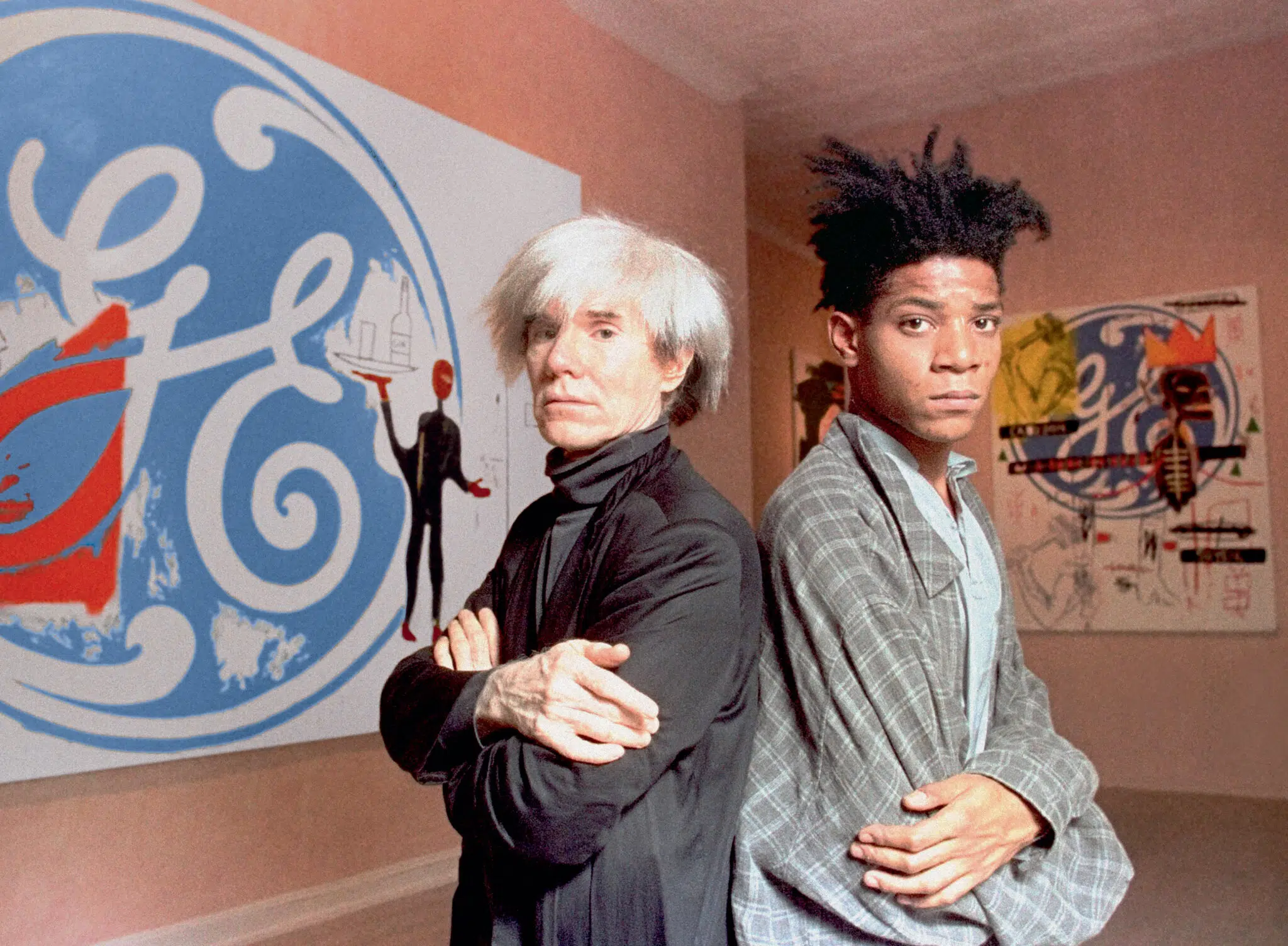 Andy Warhol and Basquiat pose in front of their collaborative paintings on display at Tony Shafrazi Gallery in New York, 1985. (Photo: Richard Drew / AP Images)