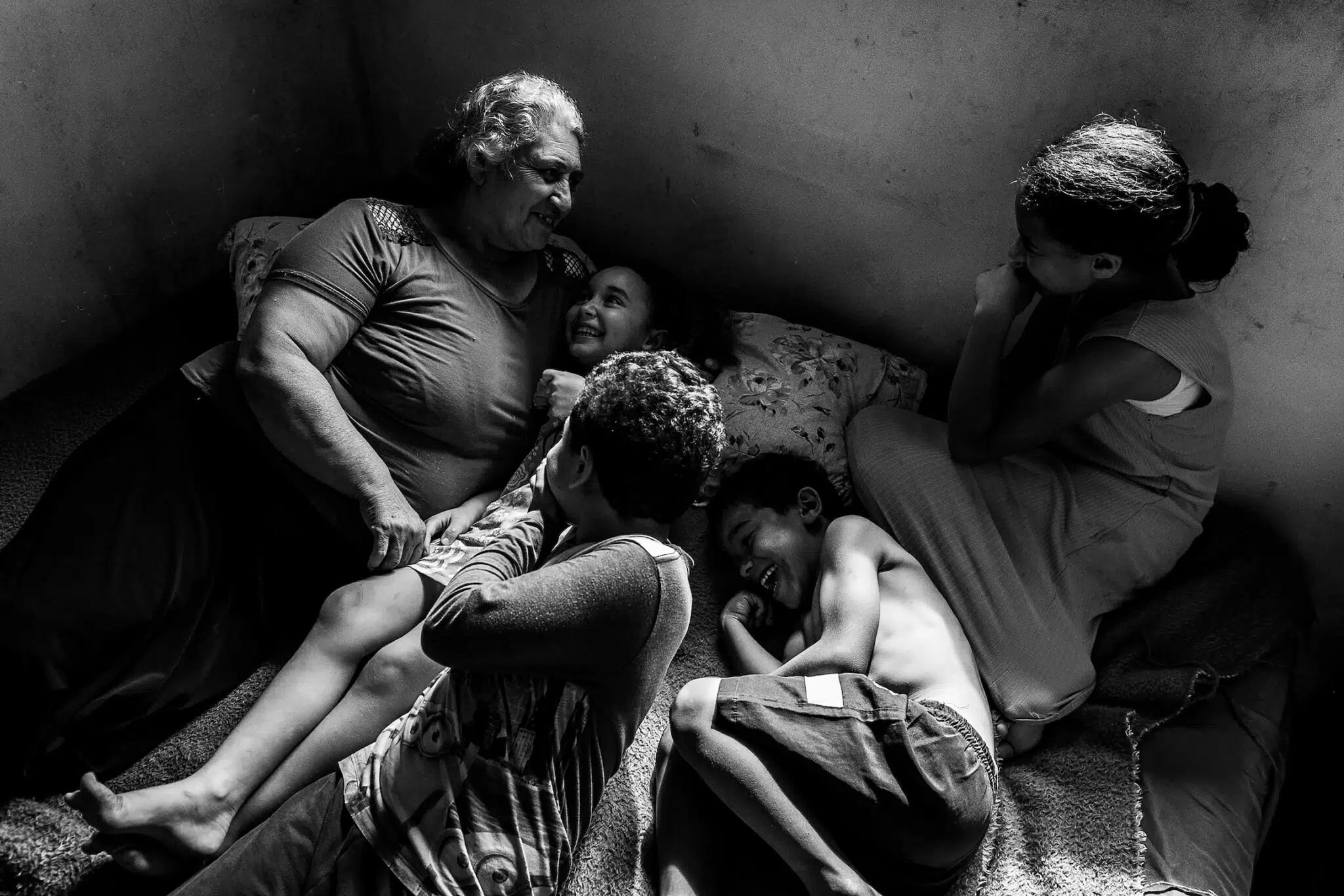 Priscila Ribeiro, &ldquo;A Territory of Hope.&rdquo; In the city of Colombo, Brazil, the Parque dos Lagos occupation is home to 200 families living without official access to water, sewage disposal, or electricity. Sandra Mara Siqueira rests with her grandchildren, Micael, Davi, Ana Fl&aacute;via, and Vit&oacute;ria. Living in the Parque dos Lagos occupation since 2013, the family seeks land regularization to guarantee access to basic infrastructure. Colombo, Paran&aacute;, Brazil, November 15, 2025.