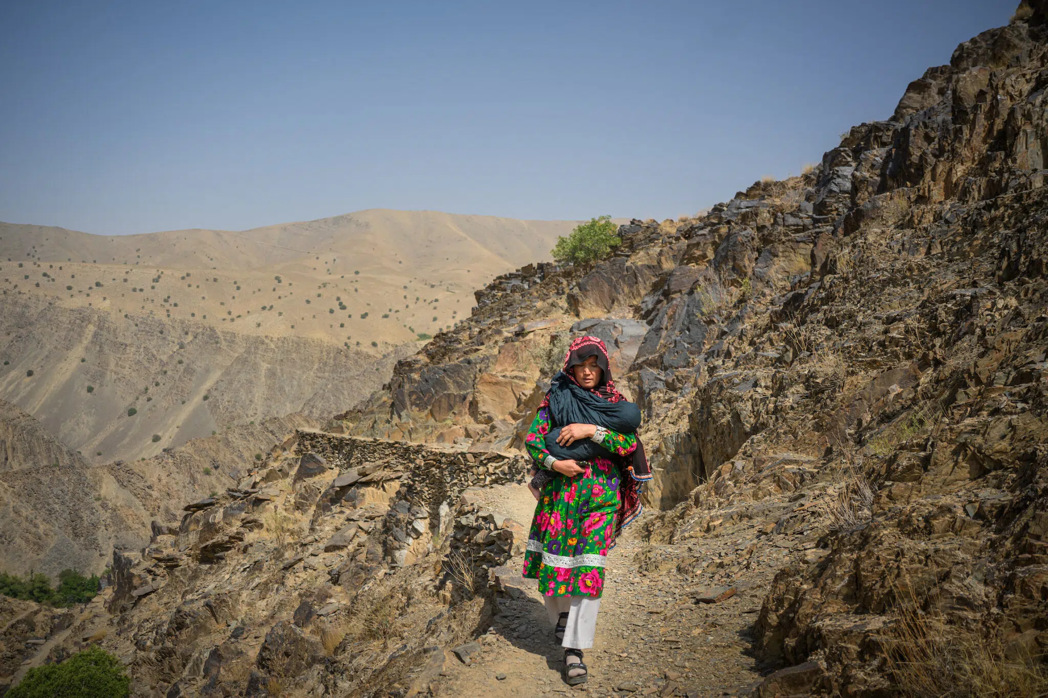 Elise Blanchard, &ldquo;&lsquo;I&rsquo;m Afraid&rsquo;: Afghan Women Face US Aid Cuts,&rdquo; for TIME. Zahira walks back from visiting a pregnant woman who is worried she might have to give birth without a midwife. Dahan-e-Tokhomak, Miramor district, Daikundi province, Afghanistan, July 24, 2025.